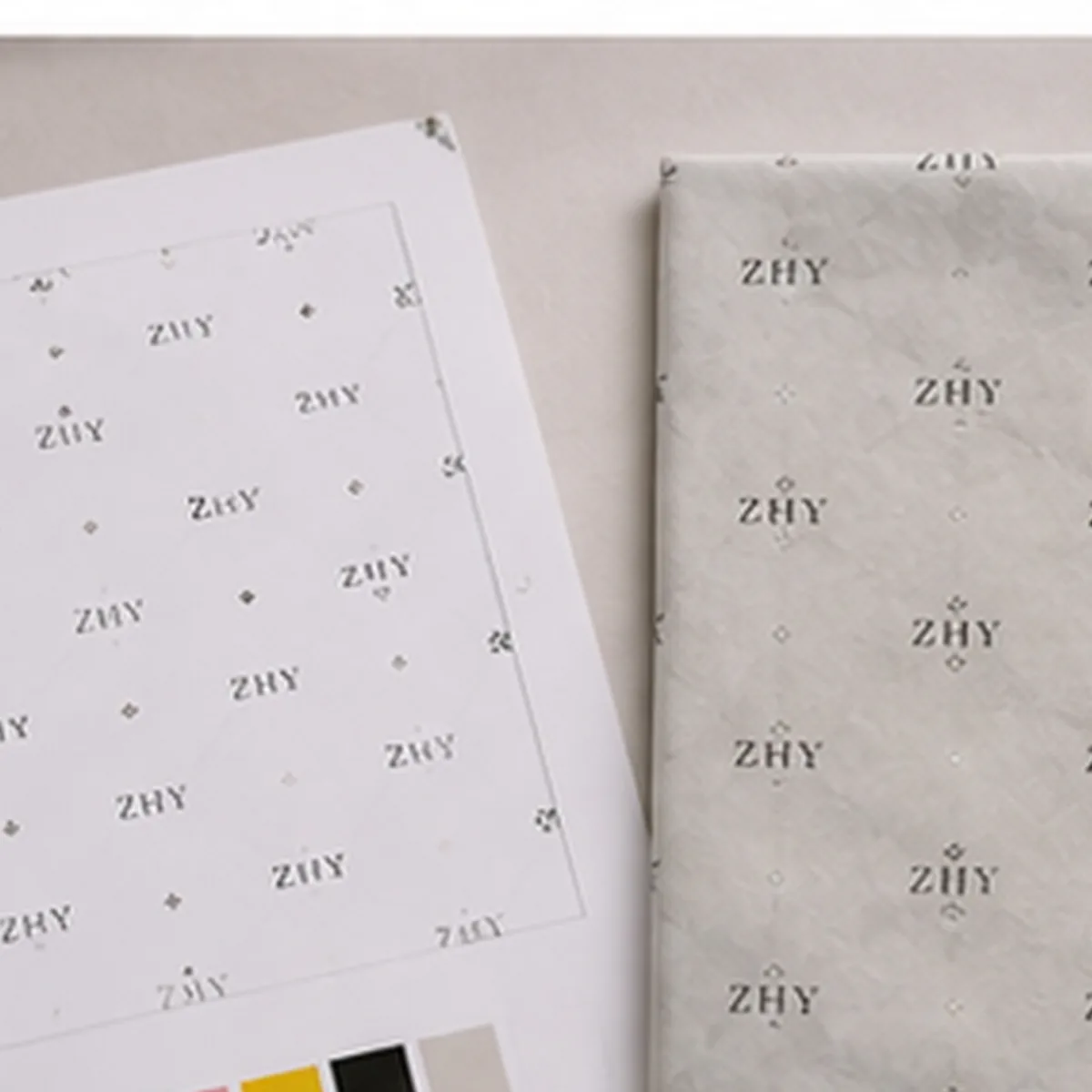 Illustrative printed tissue paper sample beside artwork references